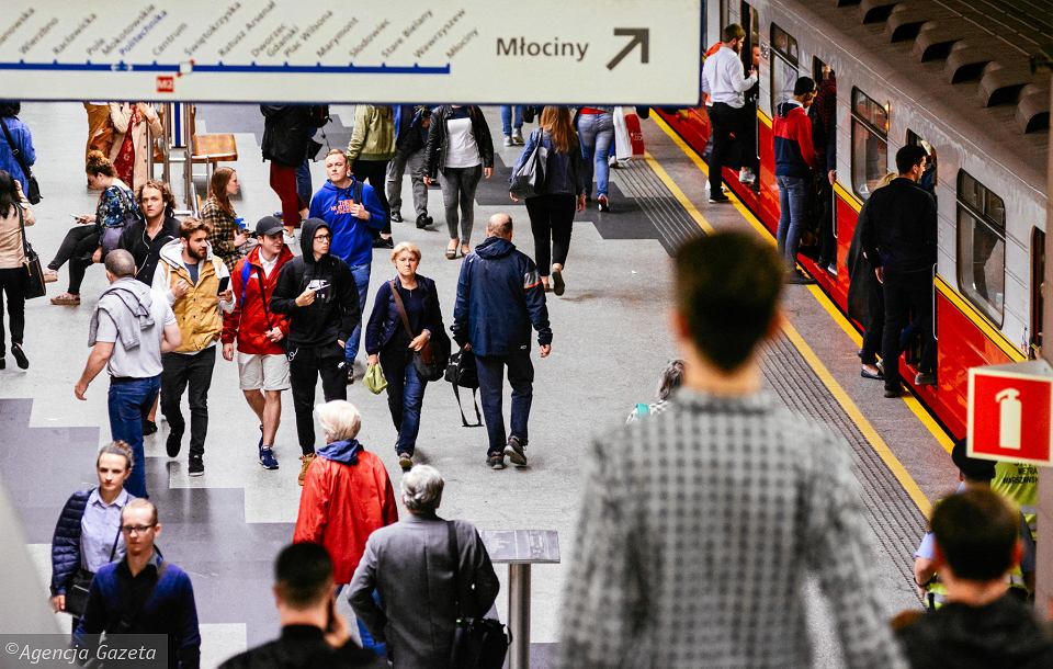 Crowd of people walking through a Warsaw metro station