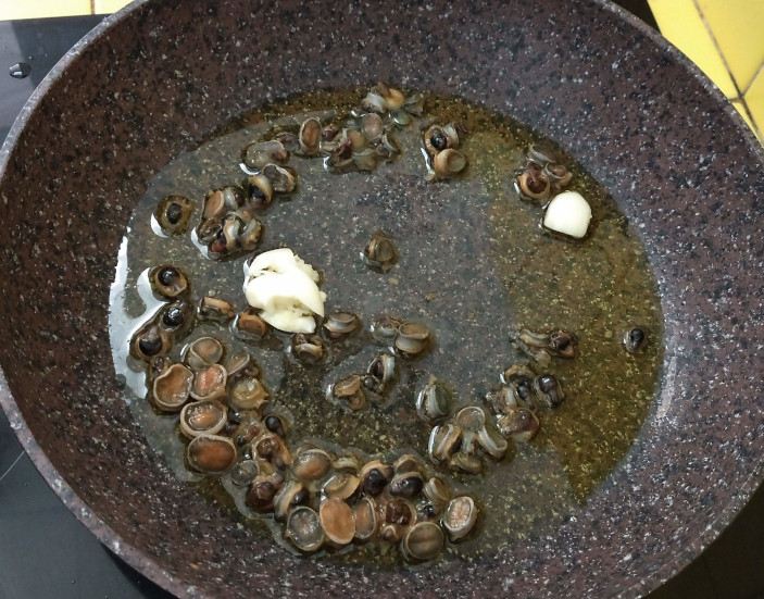 Sea snails cooking in a pan