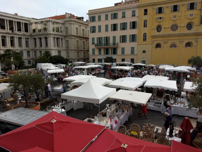Outdoor flea market in Nice with stalls and red umbrellas