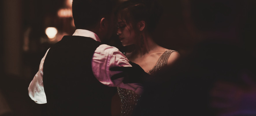 Couple dancing tango in a dimly lit room